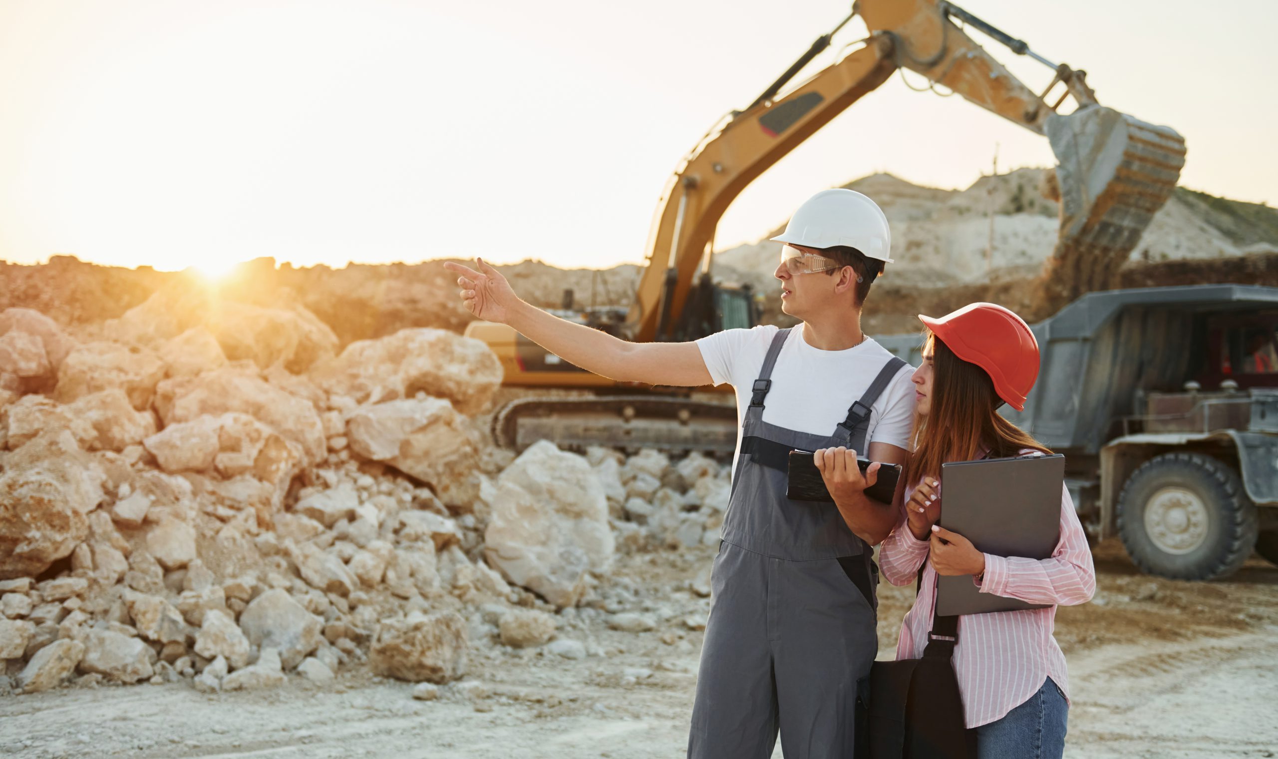 Successful teamwork. Two people is on the borrow pit at daytime together.